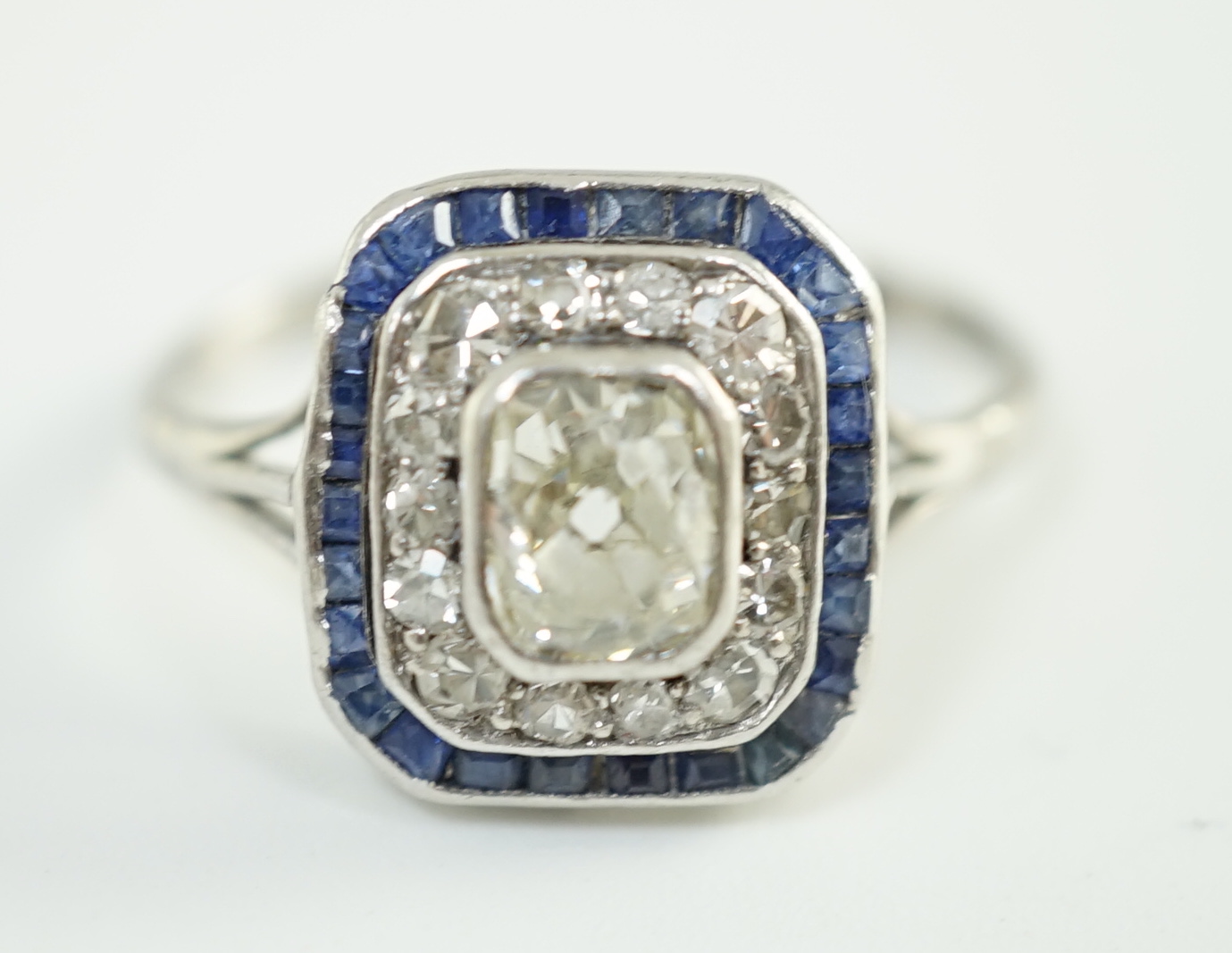 An Art Deco platinum, diamond and sapphire set rectangular cluster ring